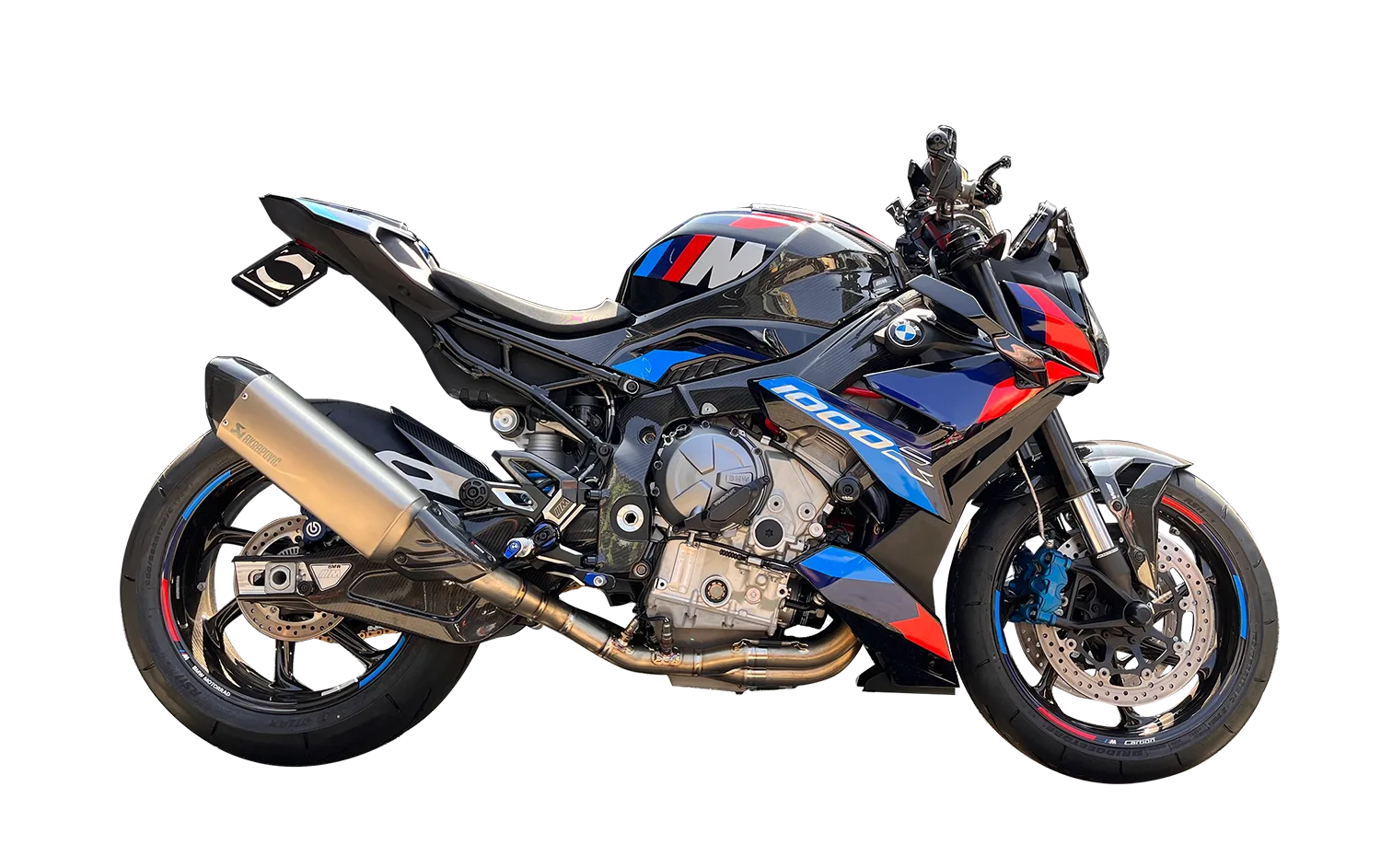 BMW S1000R naked sportbike in black, blue, and red livery with carbon accents and Akrapovič exhaust